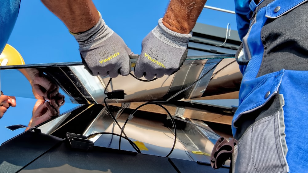 Workers installing a solar panel on a bright day